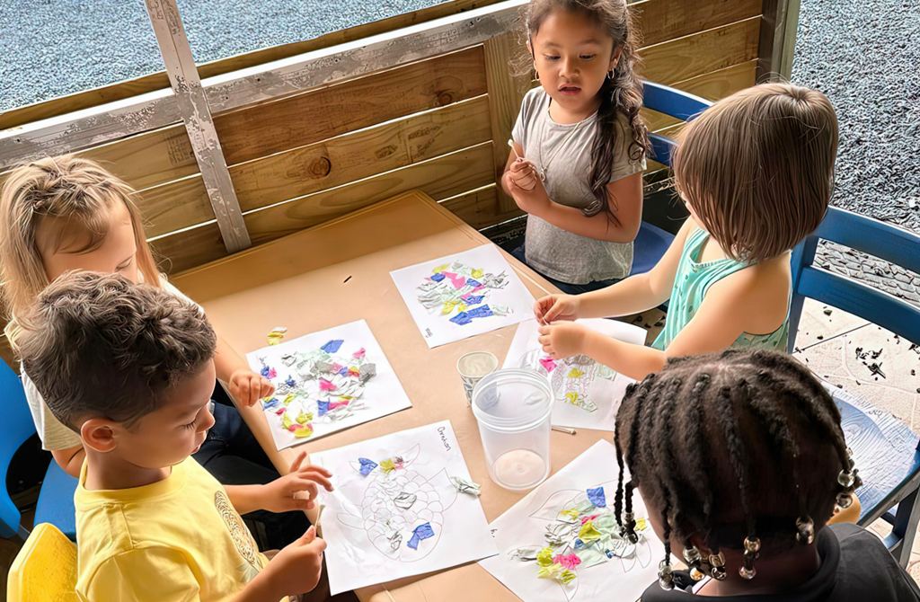 Preschoolers drawing together at a classroom table