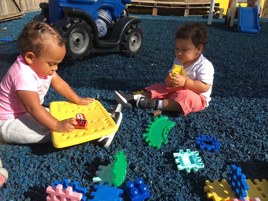 Toddlers playing together on the playground at A Child's Galaxy Preschool