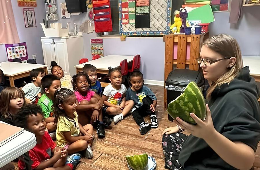 Preschoolers gathered for a lesson with their teacher